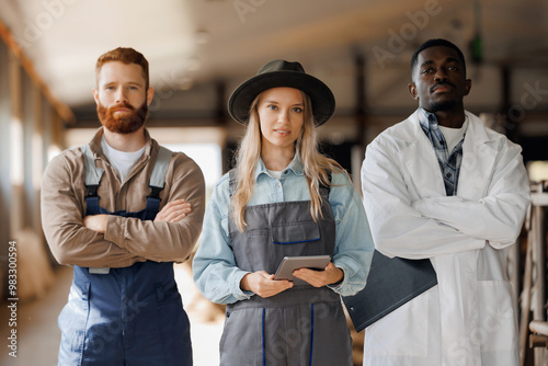 Portrait team of industry cattle livestock. Veterinarian doctor, farmer, IT worker with tablet computer together on background cowshed