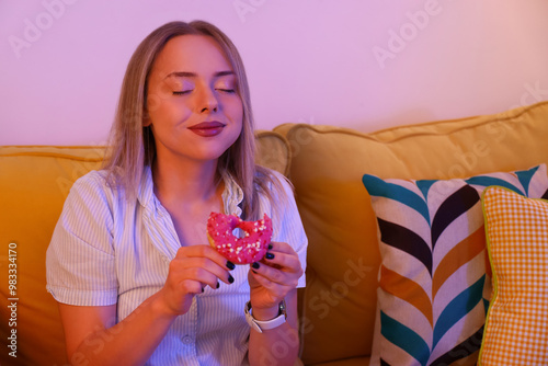 Young woman eating tasty do...