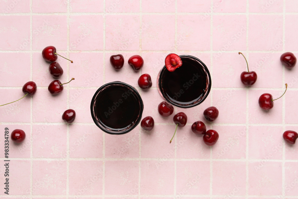 Glasses with sweet cherry liqueur on pink tile background Glasses with sweet cherry liqueur on pink tile background