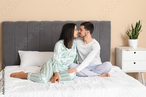 Awake young woman with her husband touching noses in bedroom