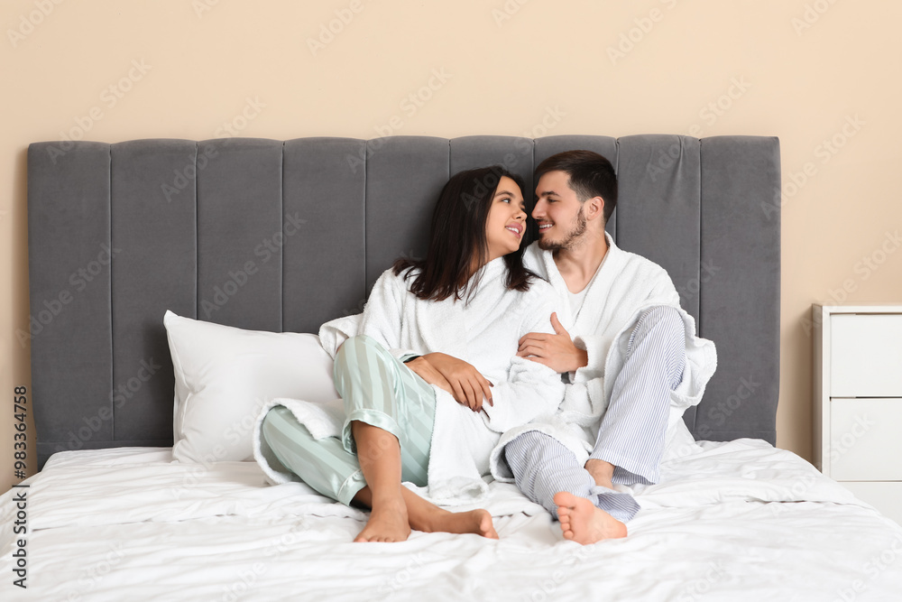 Happy young couple sitting in bedroom Happy young couple sitting in bedroom