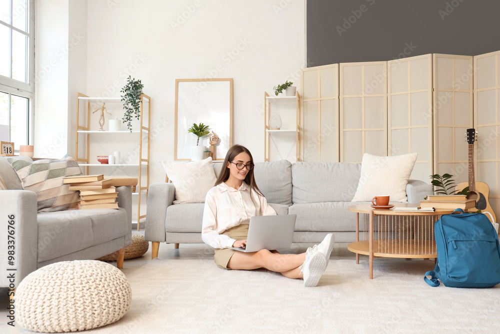 Happy female student with books, cup of coffee and laptop studying at home Happy female student with books, cup of coffee and laptop studying at home