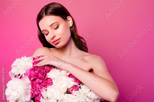 Dreamy tender girlfriend with closed eyes holding big bouquet enjoying fresh peonies empty space over pink background photo