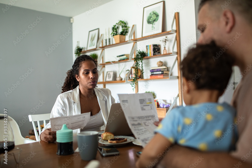 Couple managing bills with baby while working from home Couple managing bills with baby while working from home
