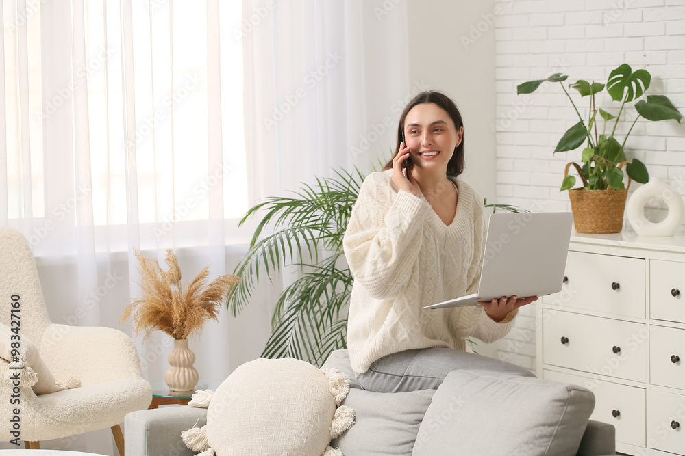 Young woman with laptop talking by mobile phone at home Young woman with laptop talking by mobile phone at home