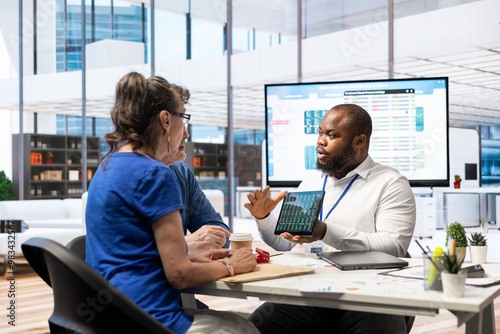 Elderly couple consulting with a financial advisor to explore beneficial retirement plans, securing life savings and pension planning. Looking into banking options for finances. photo