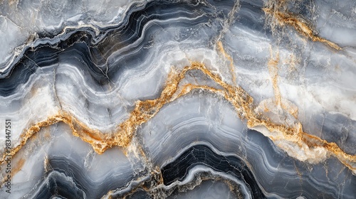 Close-up of a luxurious marble surface with a unique pattern of swirling gray, white, and gold veins.