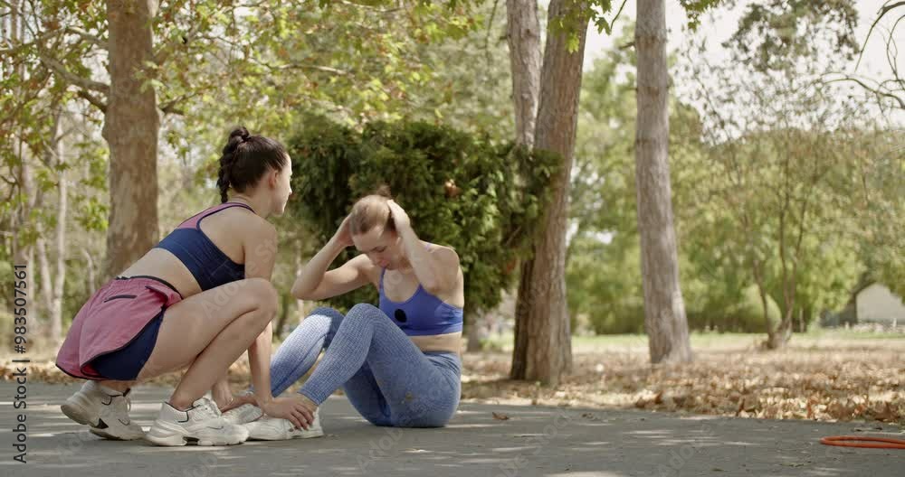 Two female friends working out together in a park, enjoying the fresh air and sunshine as they maintain their fitness. Two female friends working out together in a park, enjoying the fresh air and sunshine as they maintain their fitness.