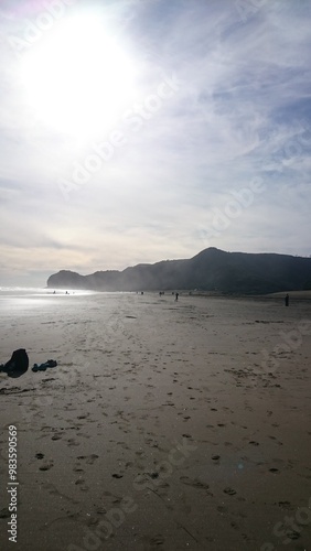 Beachcombers on Piha Beach in Auckland New Zealand Photo photo