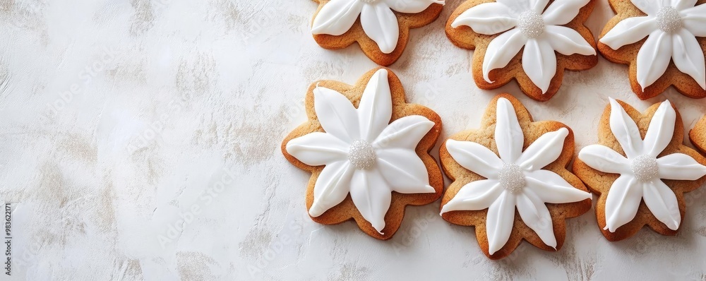 Beautifully decorated flower-shaped cookies with white icing on a light background, perfect for festivities and celebrations. Beautifully decorated flower-shaped cookies with white icing on a light background, perfect for festivities and celebrations.