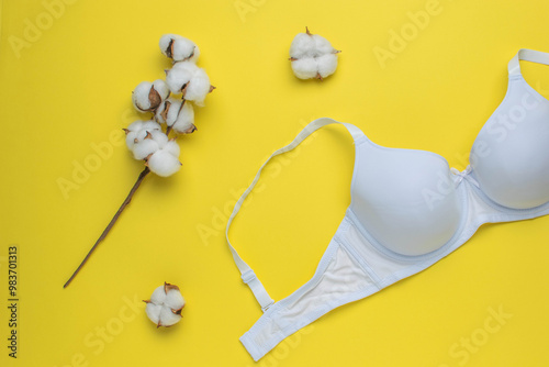 White Cotton Bra with Natural Cotton Branch on Bright Yellow Background photo