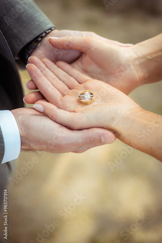 bride and groom holding hands with wedding rings