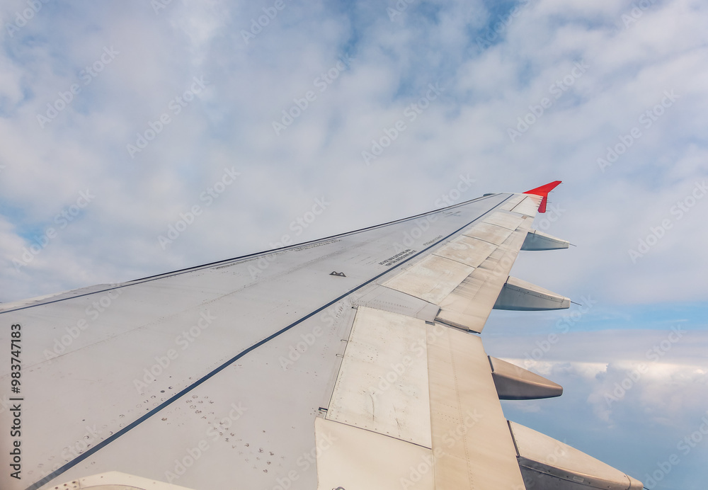 View from the airplane window at a beautiful cloudy sky and the airplane wing View from the airplane window at a beautiful cloudy sky and the airplane wing