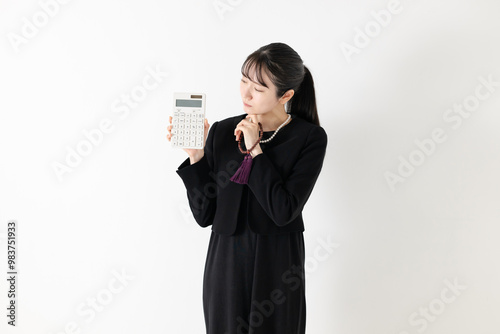 喪服姿で電卓を持つ女性 photo