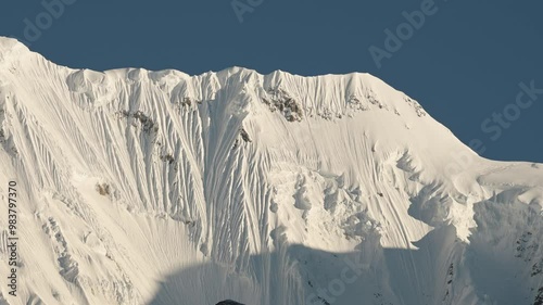 Snowy Winter Himalayas Mountain Ridge in Nepal, Close Up Snowcapped Mountains Covered in Snow with Blue Sky while Terkking and Hiking in Nepal on Annapurna Circuit photo