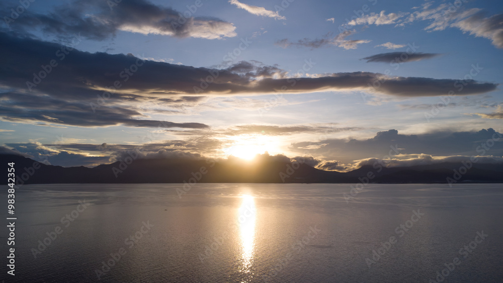 dawn over the sea against the backdrop of tropical mountains and clouds dawn over the sea against the backdrop of tropical mountains and clouds