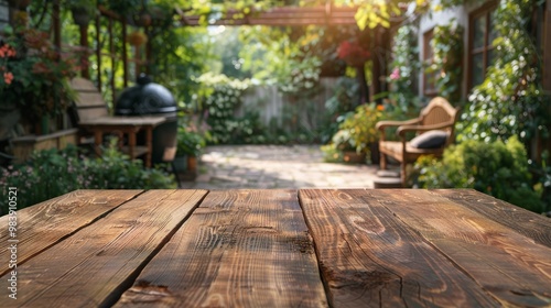 old wooden table with blur background of backyard garden and chairs and grill table. Top view 