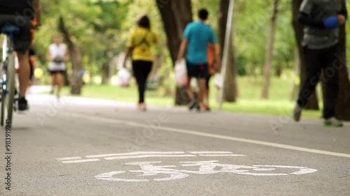 Wallpaper Mural A peaceful weekend morning scene featuring a crowd of people exercising and riding bikes through a lush park. Soft sunlight filters through trees, creating a calm, active atmosphere Torontodigital.ca