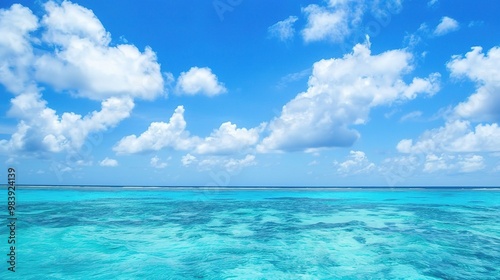 A beautiful scene of the blue ocean against the blue sky background. The ocean stretches out as far as the eye can see, with its surface glistening in the sunlight