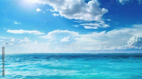 A beautiful scene of the blue ocean against the blue sky background. The ocean stretches out as far as the eye can see, with its surface glistening in the sunlight