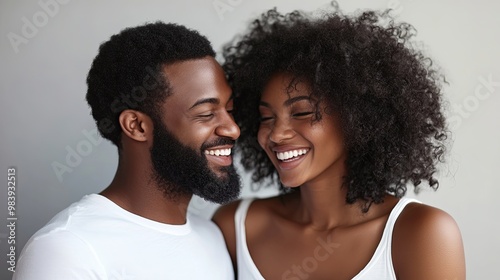 Portrait of a happy couple sharing a joyful and intimate moment, standing together with smiles on their faces. The clean background emphasizes the simplicity and purity of their connection