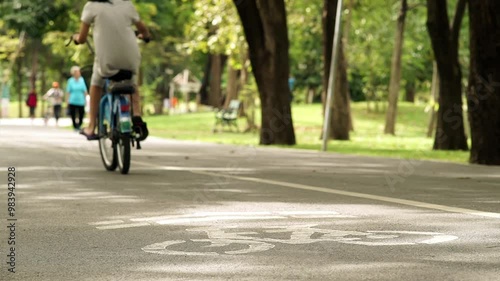 Wallpaper Mural A peaceful weekend morning scene featuring a crowd of people exercising and riding bikes through a lush park. Soft sunlight filters through trees, creating a calm, active atmosphere Torontodigital.ca