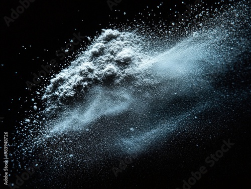 Close-up view of powdered substance on a dark background, showcasing dynamic movement and texture of fine particles.