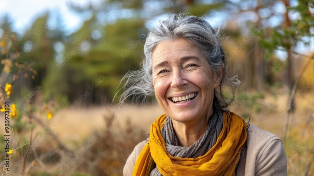 Elderly woman with gray hair and yellow scarf, wearing a patterned dress, smiling contentedly as she enjoys the outdoors on a sunny day. Elderly woman with gray hair and yellow scarf, wearing a patterned dress, smiling contentedly as she enjoys the outdoors on a sunny day.