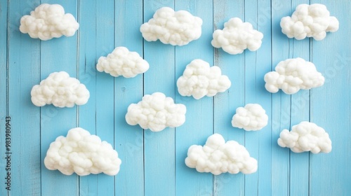 White fluffy clouds arranged on a soft blue wooden backdrop resembling a baby s nursery or children s theme with a charming playful design photo