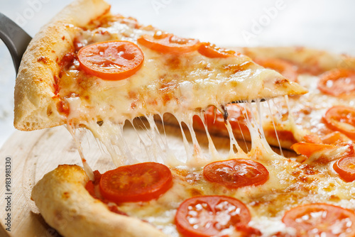 Cheese pizza with tomato slices on wooden board