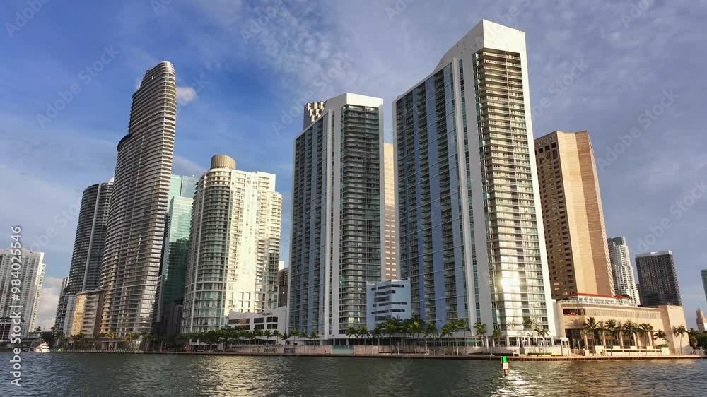 Downtown Miami waterfront with high-rise condos and office towers along the river. The sleek modern buildings line the edge of the water, creating a dynamic urban skyline. Aerial. Downtown Miami waterfront with high-rise condos and office towers along the river. The sleek modern buildings line the edge of the water, creating a dynamic urban skyline. Aerial.