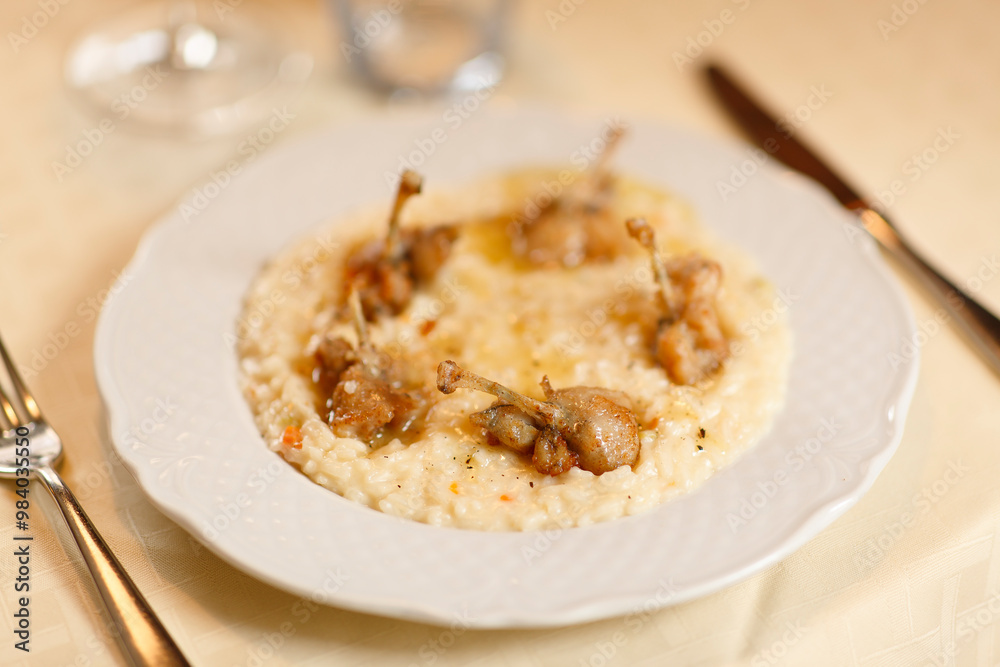 Close up on italian traditional northern food on a restaurant table. Risotto with frogs legs. Close up on italian traditional northern food on a restaurant table. Risotto with frogs legs.