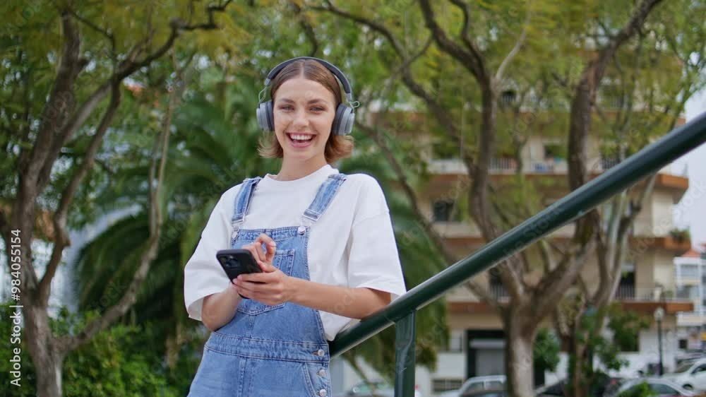 Carefree teenager enjoy music in earphones turning on phone app at park closeup Carefree teenager enjoy music in earphones turning on phone app at park closeup
