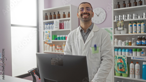 Young hispanic man smiling in pharmacy store with shelves of products in background