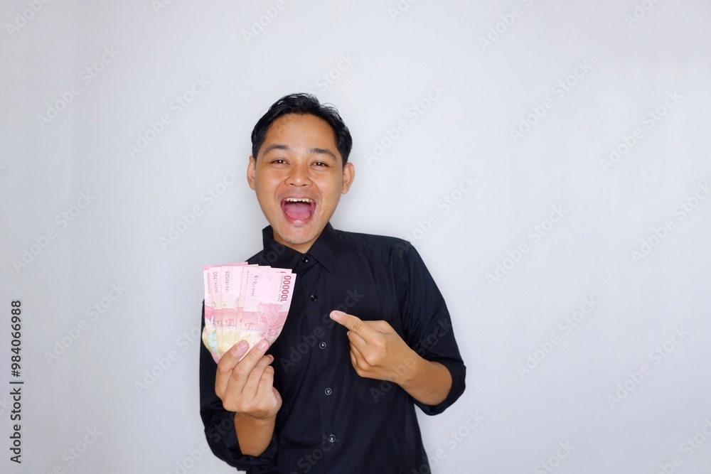 Random expression of adult Asian Indonesian man while holding banknotes isolated on white background Random expression of adult Asian Indonesian man while holding banknotes isolated on white background