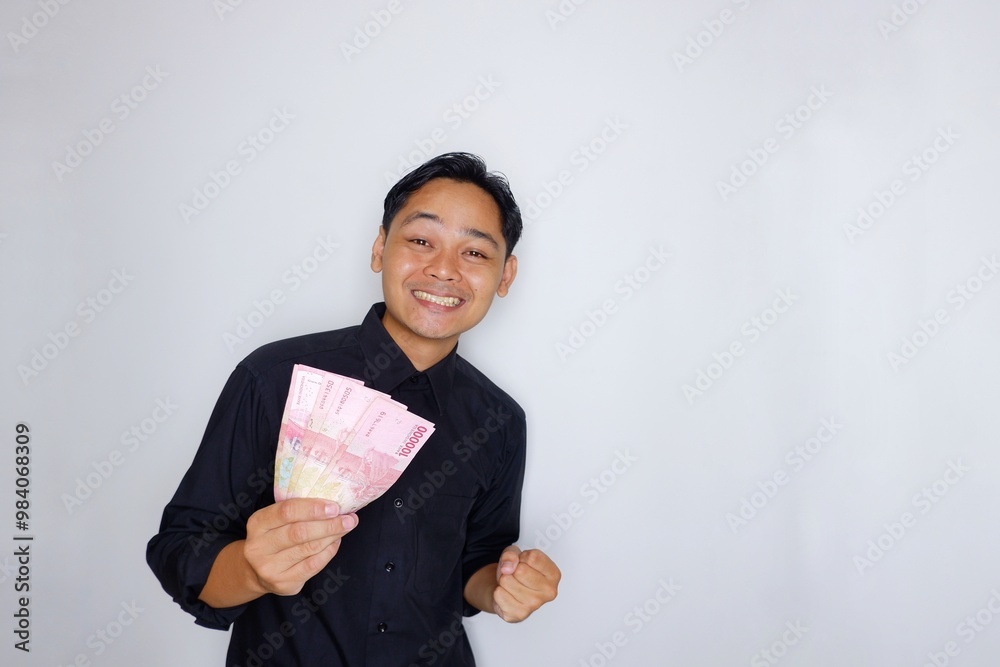 Random expression of adult Asian Indonesian man while holding banknotes isolated on white background Random expression of adult Asian Indonesian man while holding banknotes isolated on white background