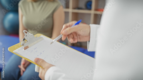 Wallpaper Mural A woman listens carefully as a healthcare professional takes notes during a consultation in a clinic. Torontodigital.ca