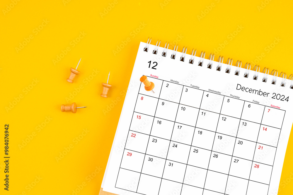 December 2024 Monthly desk calendar for 2024 year with wooden pin on yellow background. December 2024 Monthly desk calendar for 2024 year with wooden pin on yellow background.