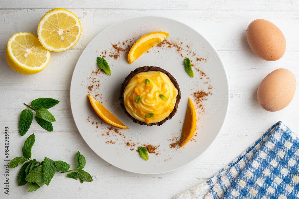 Chocolate tartlets with orange cream. Top view table with decoration. Chocolate tartlets with orange cream. Top view table with decoration.