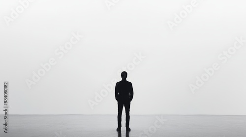 Silhouette of a businessman standing in front of an empty wall