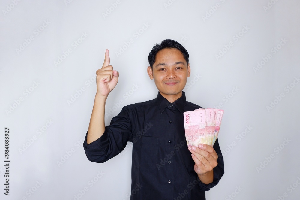 Random expression of adult Asian Indonesian man while holding banknotes isolated on white background Random expression of adult Asian Indonesian man while holding banknotes isolated on white background