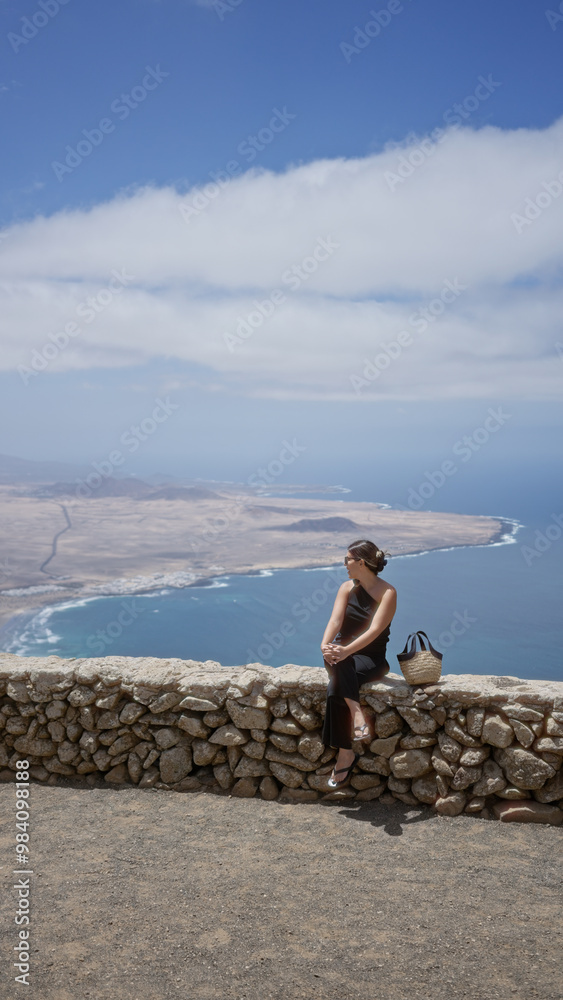 Woman sightseeing in lanzarote, canary islands with a beautiful coastal view in the background Woman sightseeing in lanzarote, canary islands with a beautiful coastal view in the background