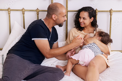 Parents with daughter on bed photo