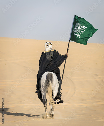 Arabian Warrior, riding his white stallion with Saudi Arabian flag in the empt quarter desert