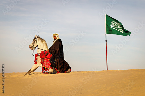 Arabian Warrior riding his white stallion celebrating National Saudi Day and Founding day in the middle of empty quarter photo