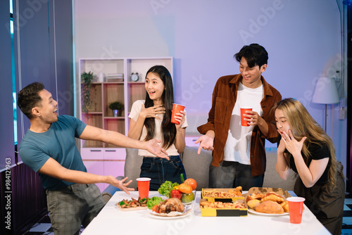 Young Asian Friends Celebrating with Laughter and Food at a Modern Evening Party