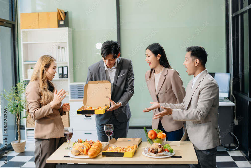 Fototapeta premium Young Asian Professionals Celebrating with Pizza and Drinks in a Modern Office Setting