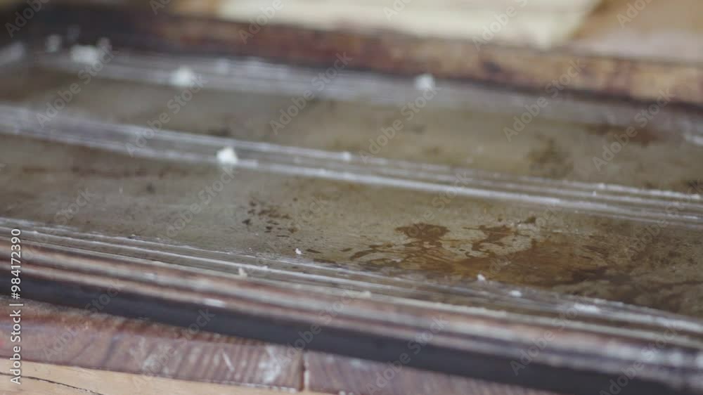 A baker places twisted dough pieces onto a baking sheet, preparing them for baking. A baker places twisted dough pieces onto a baking sheet, preparing them for baking.