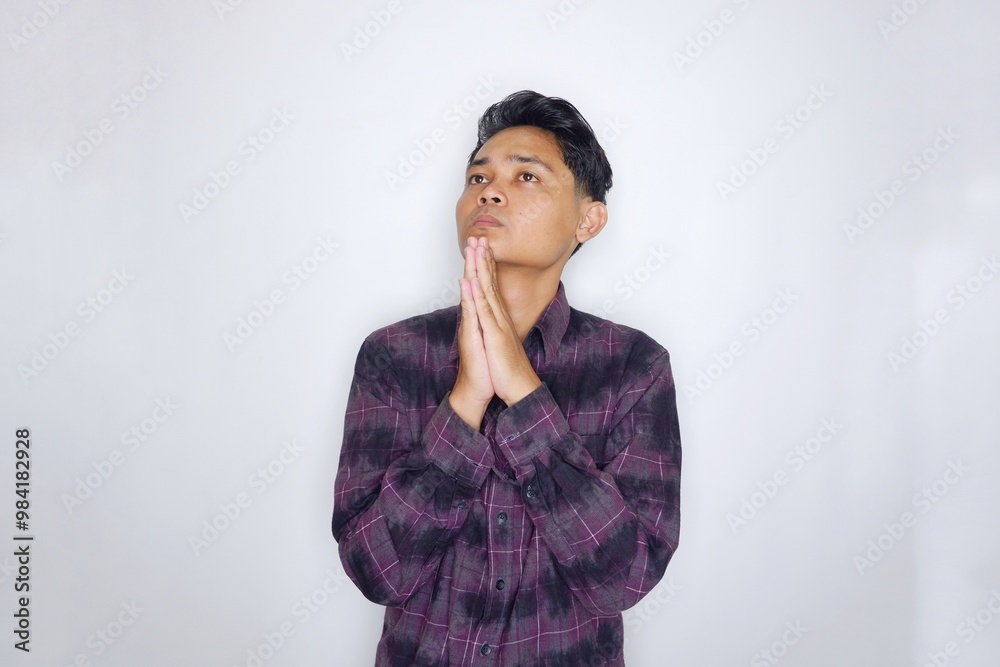 Portrait of a handsome Indonesian man in a purple flannel shirt, posing randomly on an isolated white background