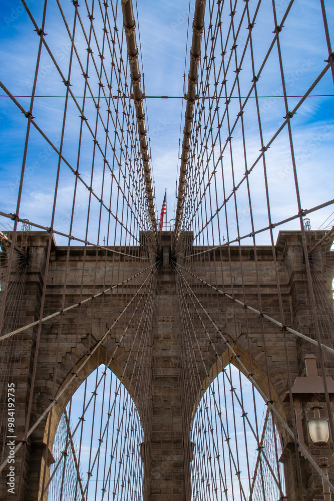 Obraz premium Detalles arquitectónicos del famoso puente de Brooklyn en New York, USA. Cableado y arcos de piedra vistos desde abajo, desde el paso peatonal, en uno de sus dos pilares, el más cercano a Manhattan.